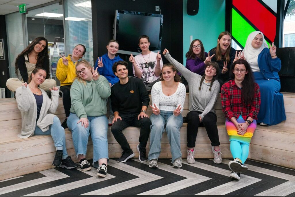 Group photograph of young people and staff members pulling funny faces